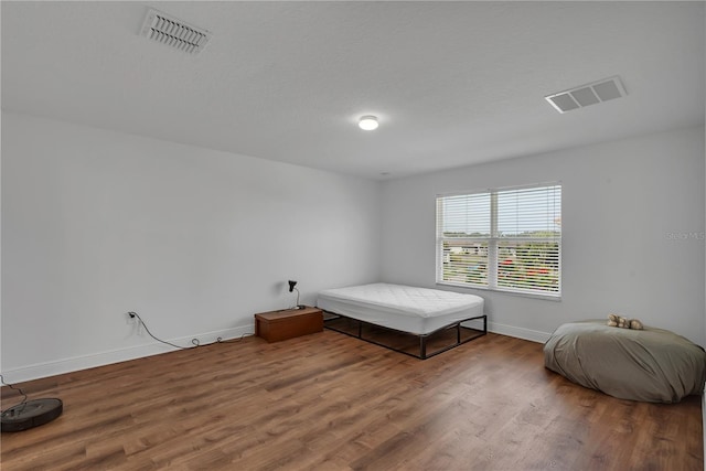 bedroom featuring wood finished floors and baseboards