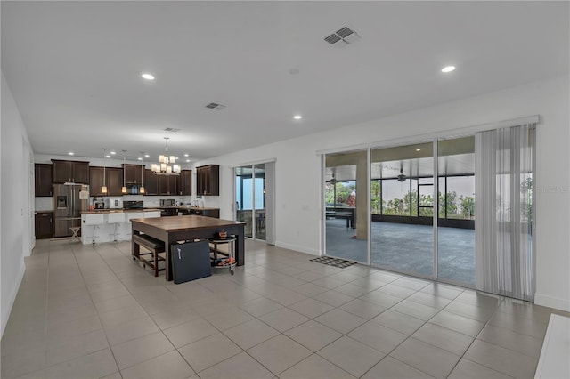 dining area featuring a chandelier, recessed lighting, baseboards, and light tile patterned floors