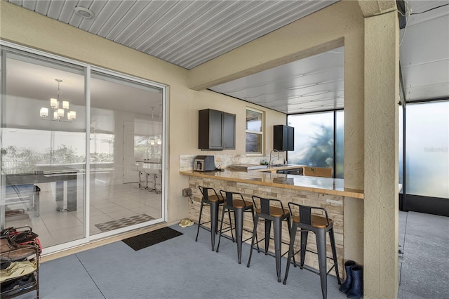 sunroom featuring a chandelier and a sink