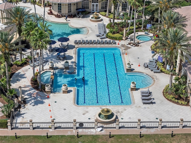 community pool with a community hot tub and a patio area