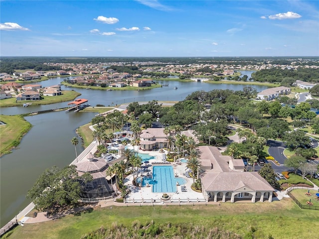 view of property location with a nearby body of water, nearby suburban area, and a pool area