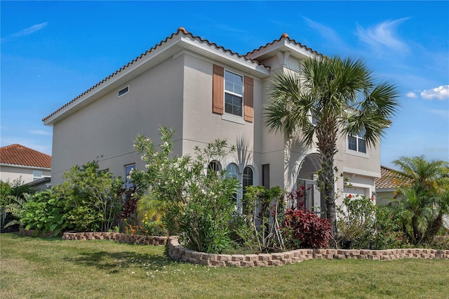 view of side of property featuring stucco siding, a lawn, and a tile roof
