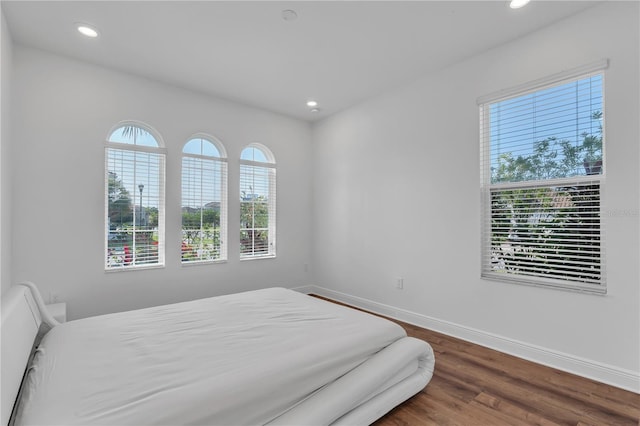 bedroom with recessed lighting, baseboards, and wood finished floors