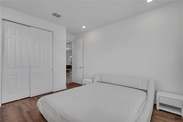 bedroom featuring recessed lighting, wood finished floors, and a closet