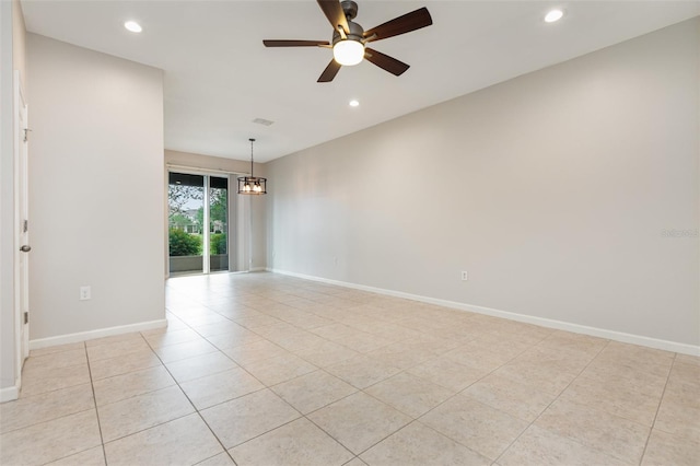empty room featuring light tile patterned flooring, recessed lighting, baseboards, ceiling fan, and a chandelier