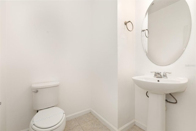 bathroom featuring toilet, baseboards, and tile patterned floors