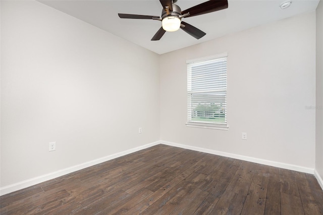 spare room featuring baseboards, dark wood finished floors, and a ceiling fan