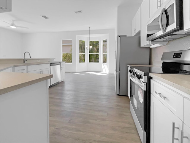 5154 51st Ln W, Bradenton, FL 34210 - kitchen featuring ceiling fan, white cabinetry, light wood finished floors, and appliances with stainless steel finishes