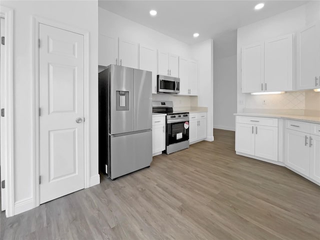 5154 51st Ln W, Bradenton, FL 34210 - kitchen with stainless steel appliances, white cabinets, and light wood-style floors