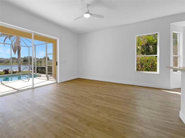 5154 51st Ln W, Bradenton, FL 34210 - empty room with a ceiling fan, baseboards, a sunroom, and wood finished floors