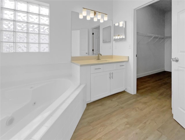5154 51st Ln W, Bradenton, FL 34210 - full bathroom featuring a tub with jets, a spacious closet, vanity, and wood finished floors