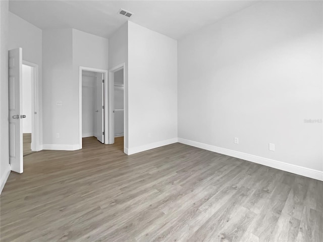 5154 51st Ln W, Bradenton, FL 34210 - unfurnished bedroom featuring wood finished floors, a closet, visible vents, baseboards, and a spacious closet