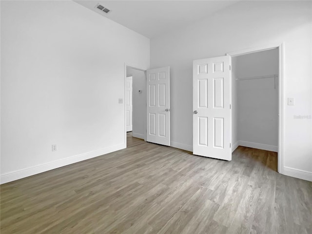 5154 51st Ln W, Bradenton, FL 34210 - unfurnished bedroom featuring lofted ceiling, baseboards, visible vents, and wood finished floors