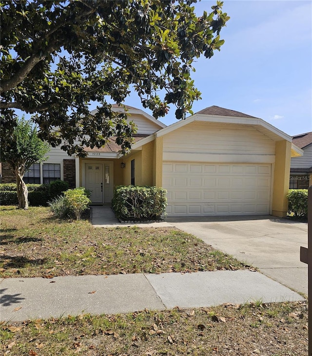 view of front of property featuring a garage, concrete driveway, and stucco siding
