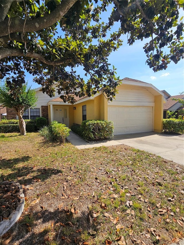 single story home featuring an attached garage, driveway, and stucco siding