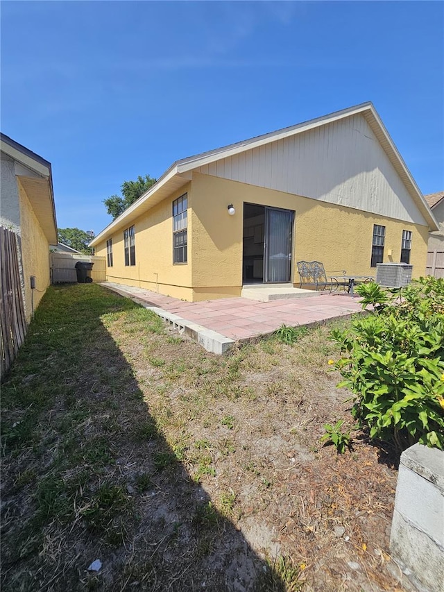back of house with fence, a patio, central AC, and stucco siding