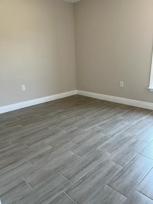 empty room with wood finished floors and baseboards