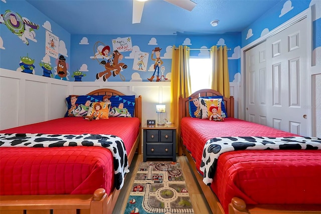 2624 Daulby St, Kissimmee, FL 34747 - bedroom with wood finished floors, a wainscoted wall, a decorative wall, ceiling fan, and a closet