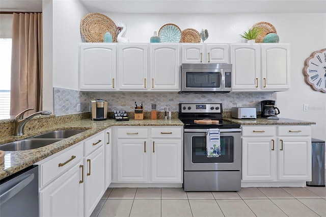 2624 Daulby St, Kissimmee, FL 34747 - kitchen with stainless steel appliances, a sink, light tile patterned flooring, and white cabinets