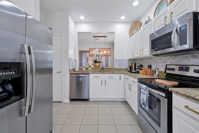 2624 Daulby St, Kissimmee, FL 34747 - kitchen featuring appliances with stainless steel finishes, a sink, backsplash, a chandelier, and light tile patterned floors