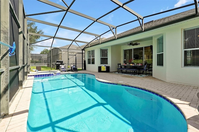 2624 Daulby St, Kissimmee, FL 34747 - view of swimming pool featuring a patio, ceiling fan, glass enclosure, a storage shed, and a pool with connected hot tub