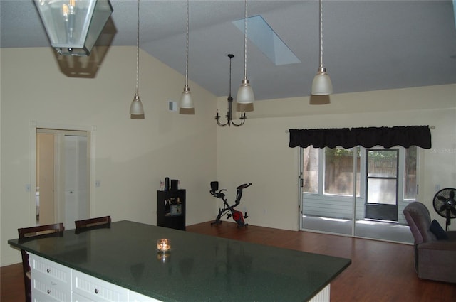 1644 Cypress Woods Cir, Saint Cloud, FL 34772 - kitchen with dark wood finished floors, open floor plan, white cabinets, lofted ceiling with skylight, and dark countertops