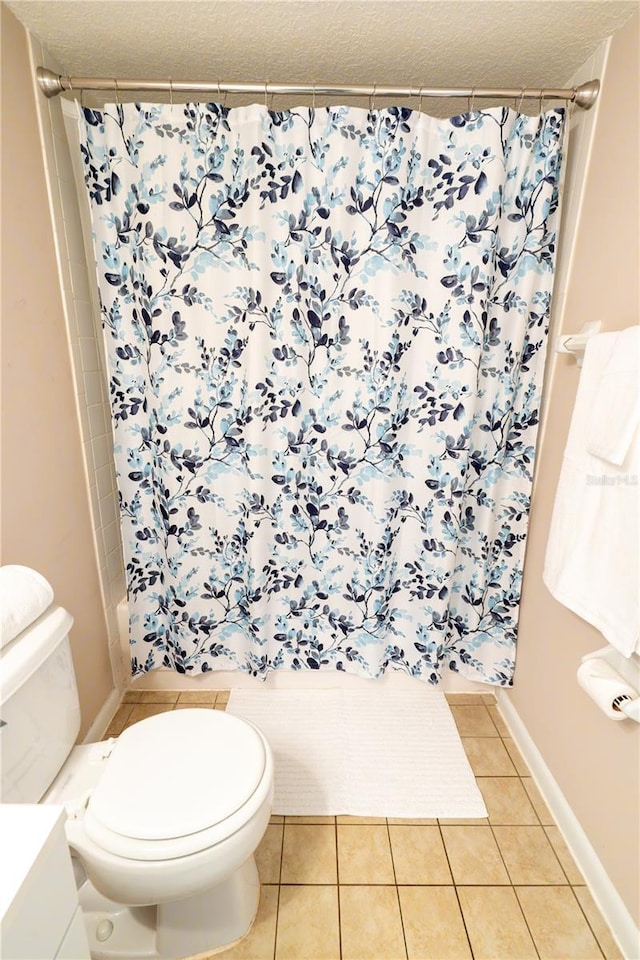 bathroom featuring toilet, a shower with shower curtain, and tile patterned flooring