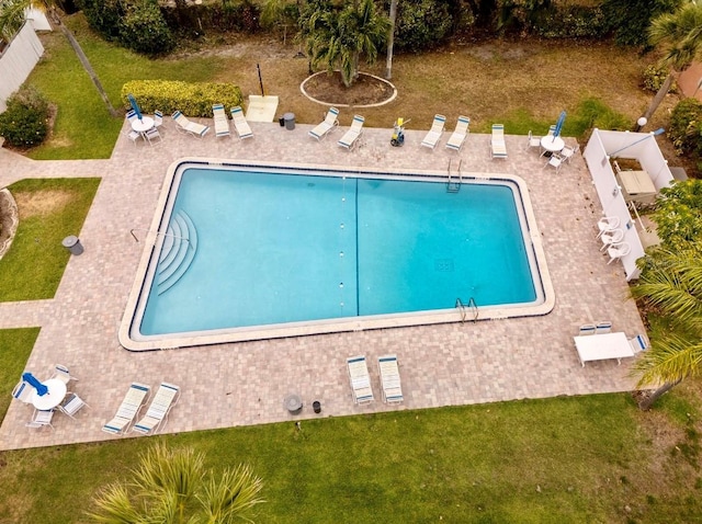 community pool with a lawn and a patio area