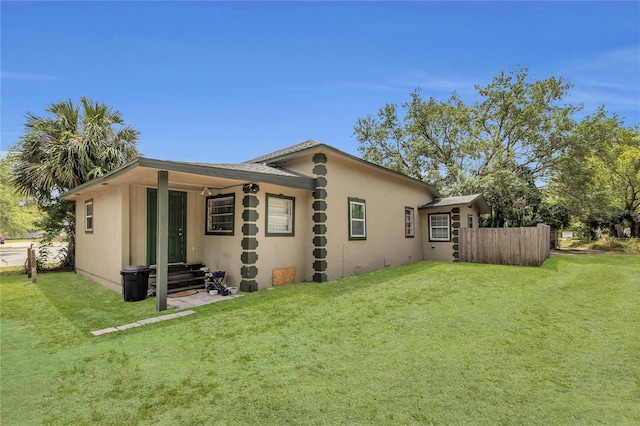 1511 W 12th St, Sanford, FL 32771 - view of property exterior featuring a lawn, entry steps, stucco siding, and fence
