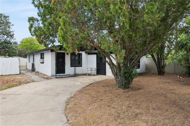 view of front facade with driveway and fence