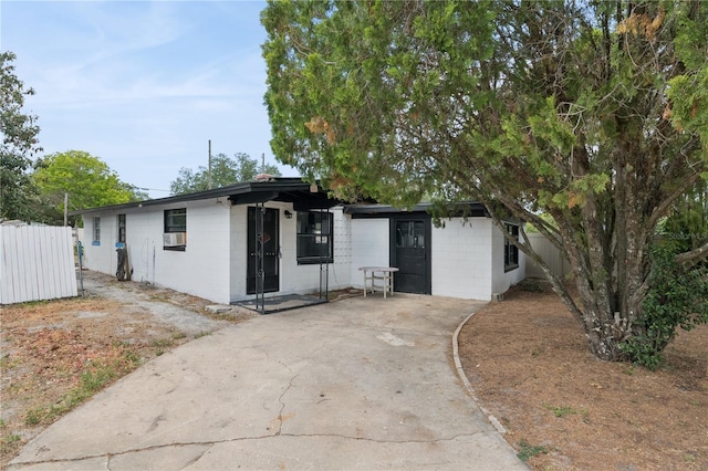 ranch-style house featuring fence and concrete block siding