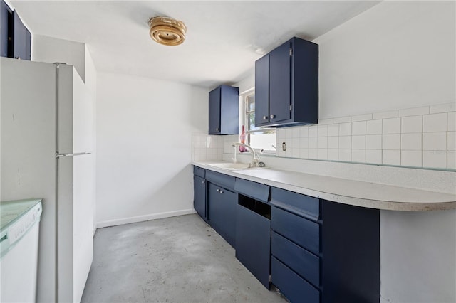 kitchen featuring a sink, unfinished concrete floors, light countertops, decorative backsplash, and blue cabinets