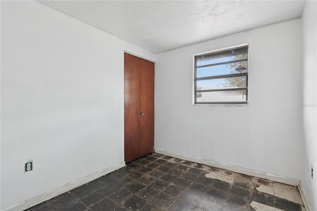 spare room with baseboards