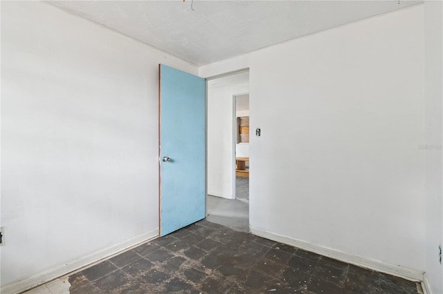 empty room with baseboards and tile patterned floors
