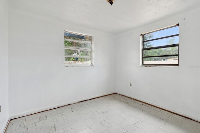 empty room with tile patterned floors and baseboards