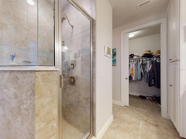 5 Riverwalk Dr Unit 601, New Smyrna Beach, FL 32169 - full bathroom featuring a stall shower, a walk in closet, and tile patterned flooring
