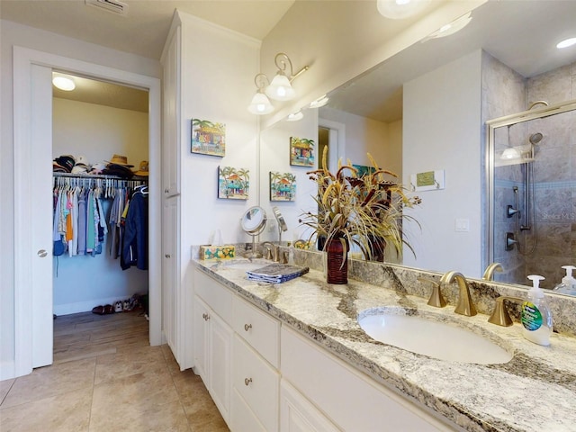 5 Riverwalk Dr Unit 601, New Smyrna Beach, FL 32169 - bathroom with a stall shower, double vanity, tile patterned flooring, a spacious closet, and baseboards