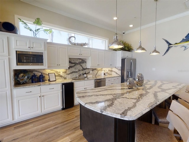 5 Riverwalk Dr Unit 601, New Smyrna Beach, FL 32169 - kitchen featuring appliances with stainless steel finishes, backsplash, a sink, white cabinetry, and ornamental molding