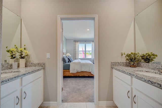 bathroom featuring a sink, two vanities, and ensuite bathroom
