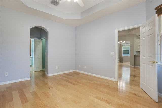3436 Gerber Daisy Ln, Oviedo, FL 32766 - spare room featuring arched walkways, light wood finished floors, ceiling fan, and baseboards