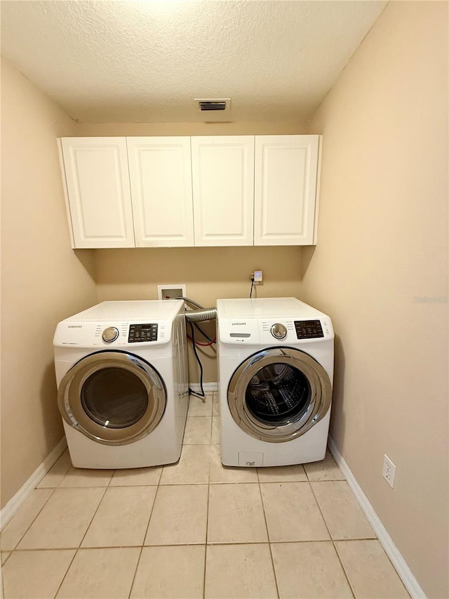 laundry room with washer and clothes dryer, cabinet space, baseboards, and visible vents
