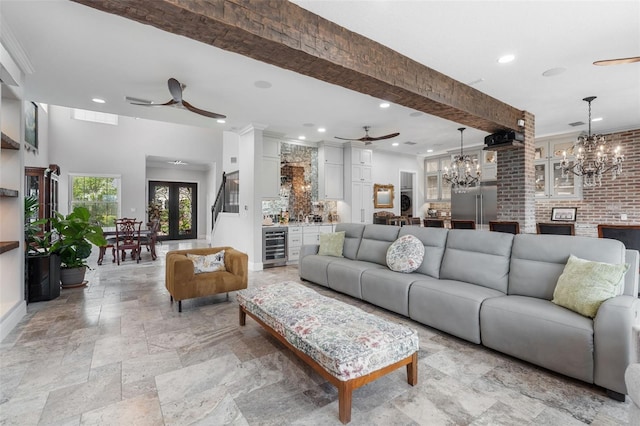 living room featuring ceiling fan, recessed lighting, beverage cooler, a chandelier, and stone tile floors