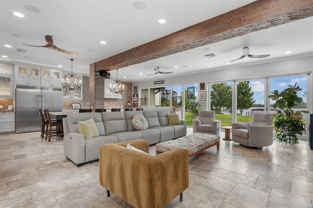 living room with ceiling fan, a chandelier, recessed lighting, stone tile floors, and crown molding