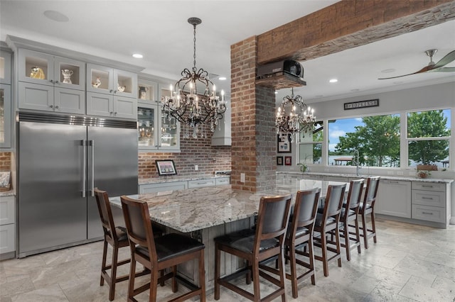 dining area featuring a chandelier, stone tile floors, ornamental molding, recessed lighting, and a ceiling fan