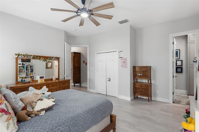 bedroom featuring light wood-type flooring, a ceiling fan, a closet, and baseboards