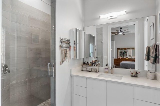 ensuite bathroom featuring ceiling fan, a stall shower, and vanity