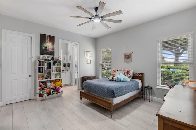bedroom with light wood-type flooring, ensuite bath, and ceiling fan