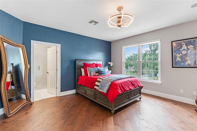 bedroom with a chandelier, wood finished floors, and baseboards