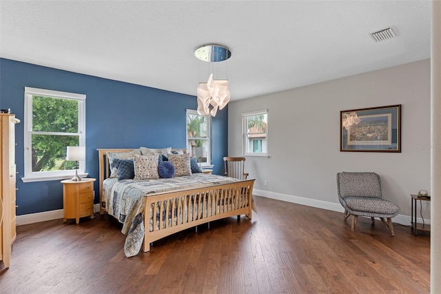 bedroom with a chandelier, baseboards, and wood finished floors