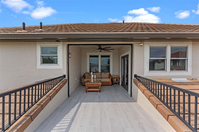 wooden deck with ceiling fan and an outdoor living space